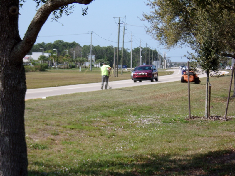 P & T Landscaping Team mowing and weed eating along the side of the road for Lee County DOT