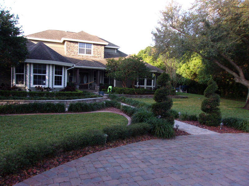 P&T Maintaining the Front Yard of a Home that has sculpted bushes that compliment the landscape design